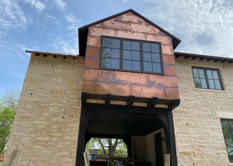 Copper metal panel facade on a stone building for Skylight Installation in East Lake
